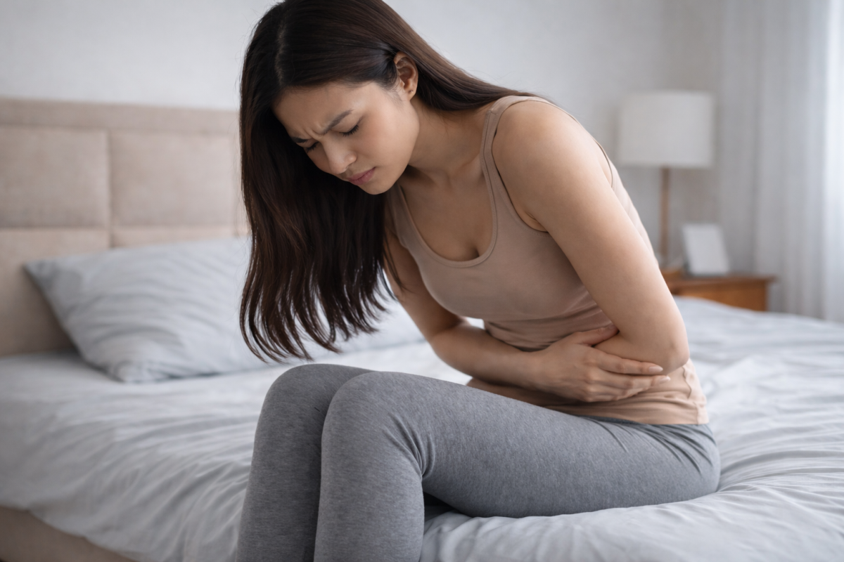 Woman experiencing lower abdominal discomfort, a possible symptom of genital Trichomoniasis infection.