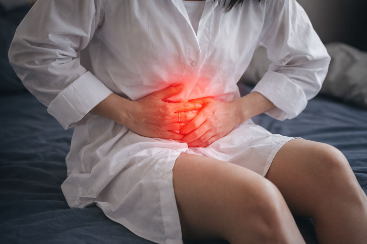 Woman holding lower abdomen with red highlight to show pelvic pain during intercourse or possible infection.