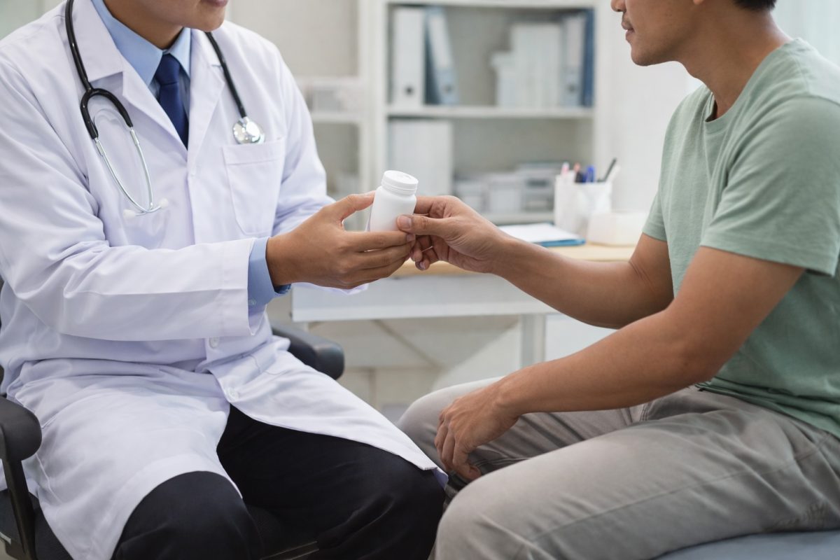 doctor giving medication to a male patient