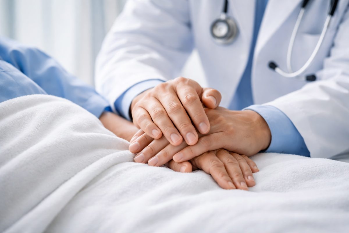 Seorang doktor memegang tangan pesakit