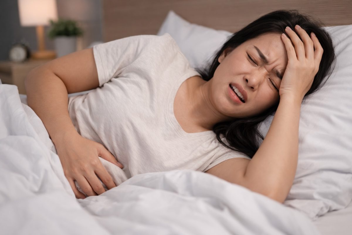 Wanita dengan ketidakselesaan berehat di atas katil