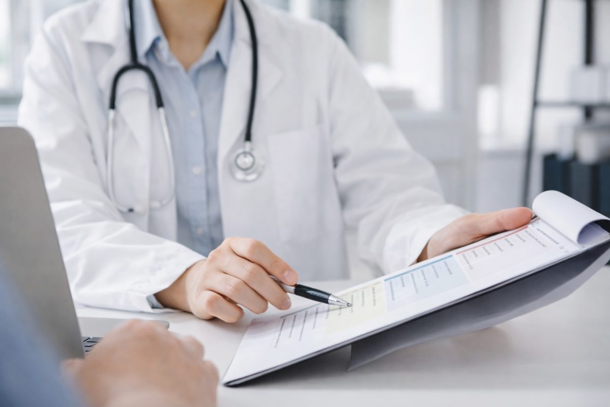 Doctor consulting patient and reviewing medical report, related to STD testing, diagnosis, and sexual health screening
